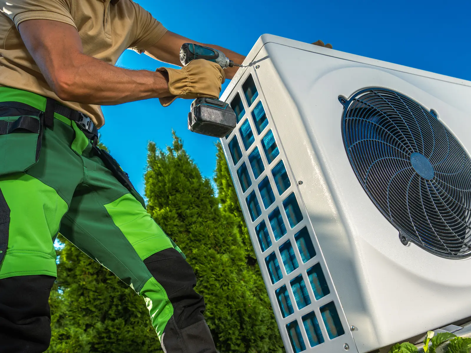 Installateur fixant le groupe extérieur d'une pompe à chaleur air-air