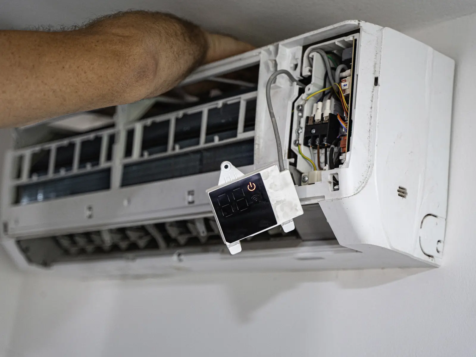 Technicien contrôlant la carte électronique d'un climatiseur lors d'une maintenance