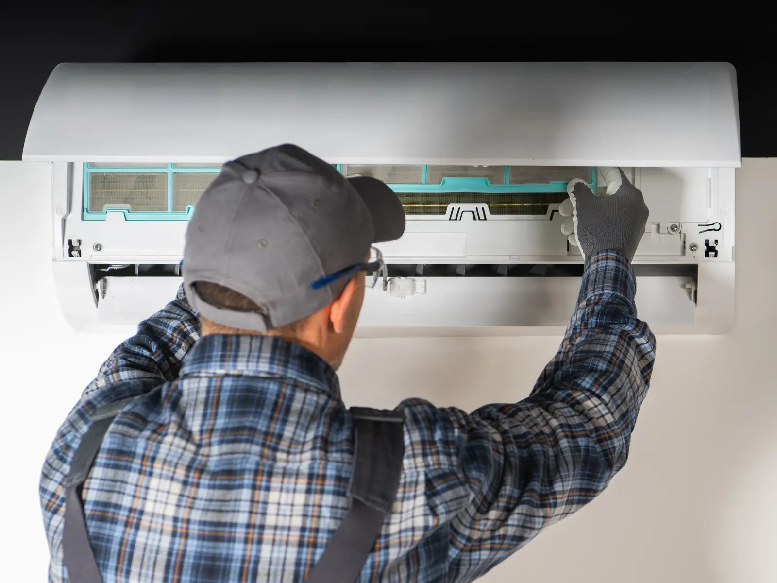 Technicien contrôlant une unité intérieure de climatisation au printemps